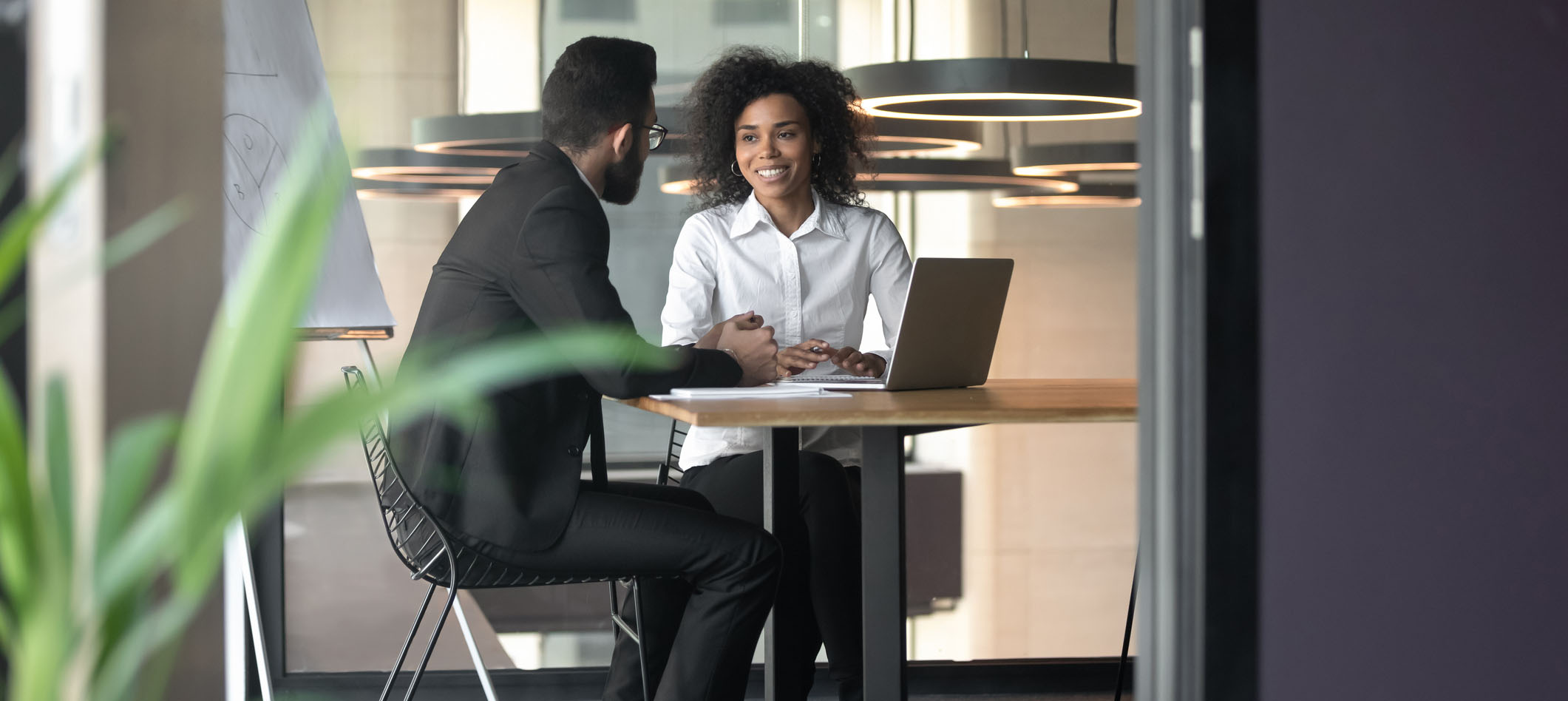 Duas pessoas (um homem e uma mulher) conversando no ambiente de trabalho
