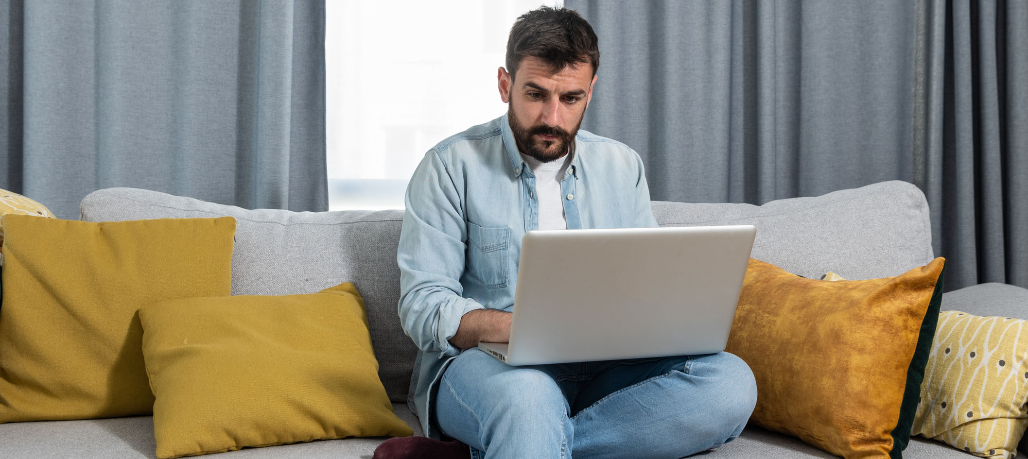 Homem trabalhando no sofa de casa