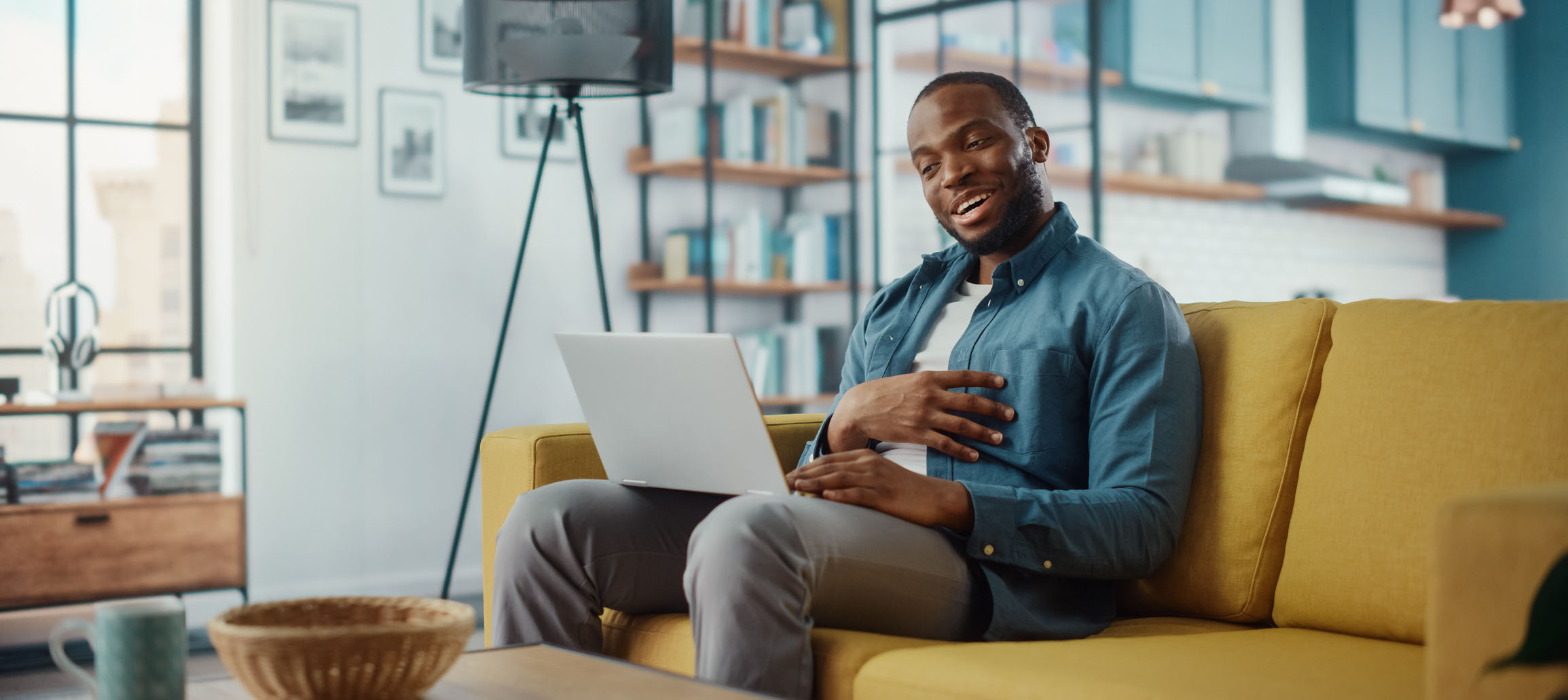 Homem olhando sorridente para o seu notebook
